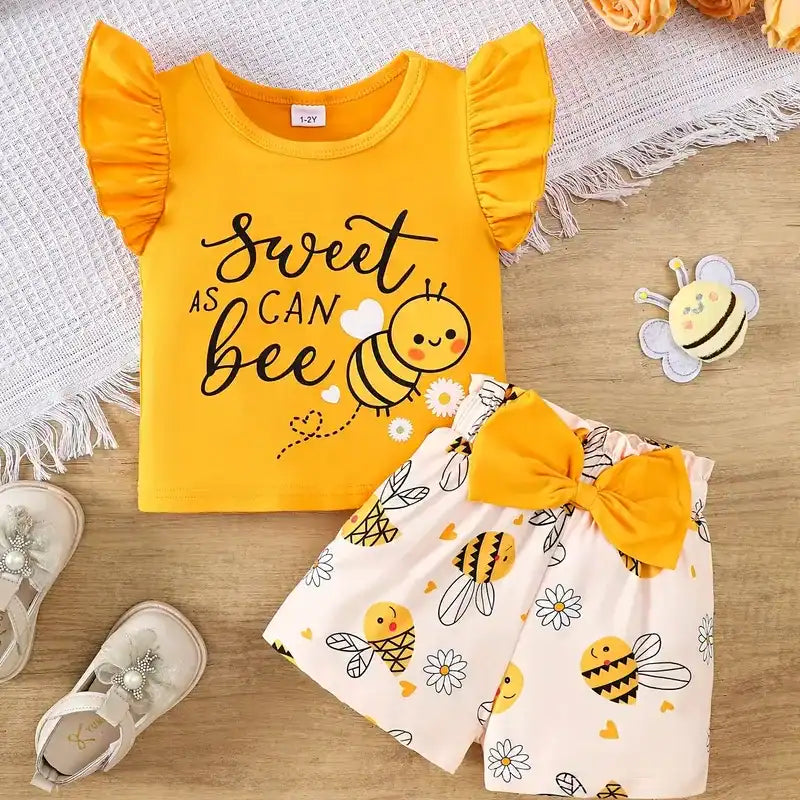 Yellow bee-themed baby outfit with "Sweet as Can Bee" tee, matching skirt with bee and flower prints, and a large bow.